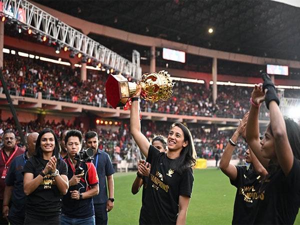 RCB team with the trophy at Bengaluru's M Chinnaswamy Stadium. (Photo- RCB X)